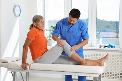 Photo of Physiotherapist working with senior patient in rehabilitation center