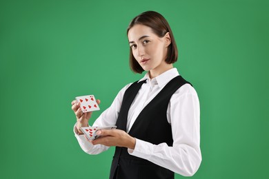 Professional croupier shuffling cards on green background