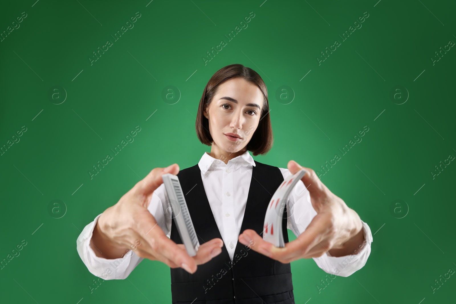 Photo of Professional croupier shuffling cards on green background