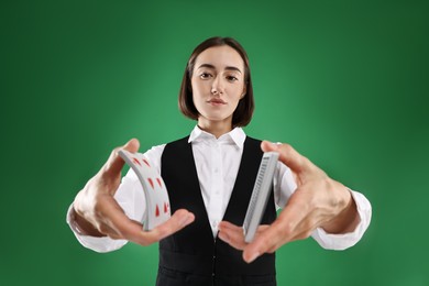 Photo of Professional croupier shuffling cards on green background