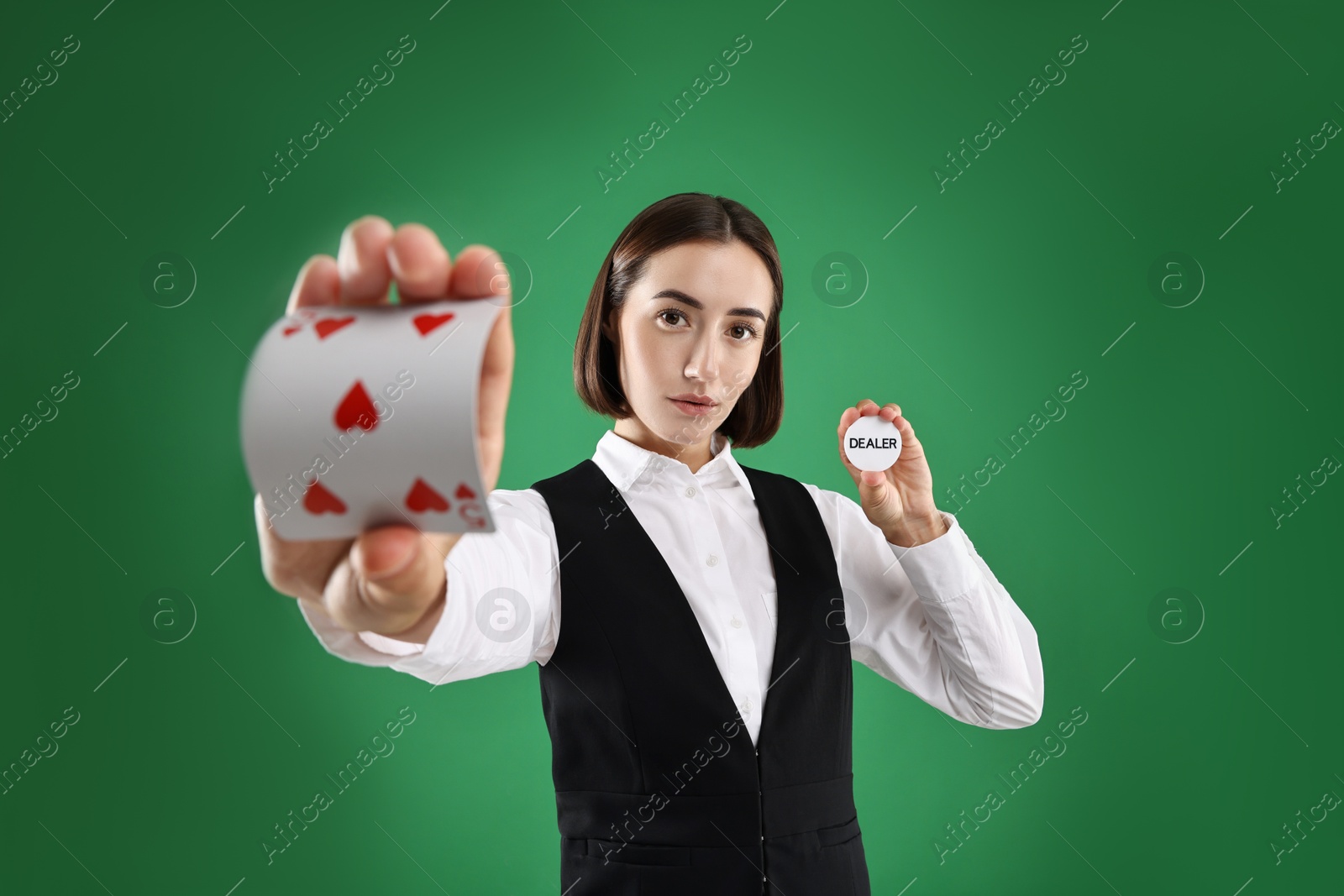 Photo of Croupier with cards and dealer button on green background