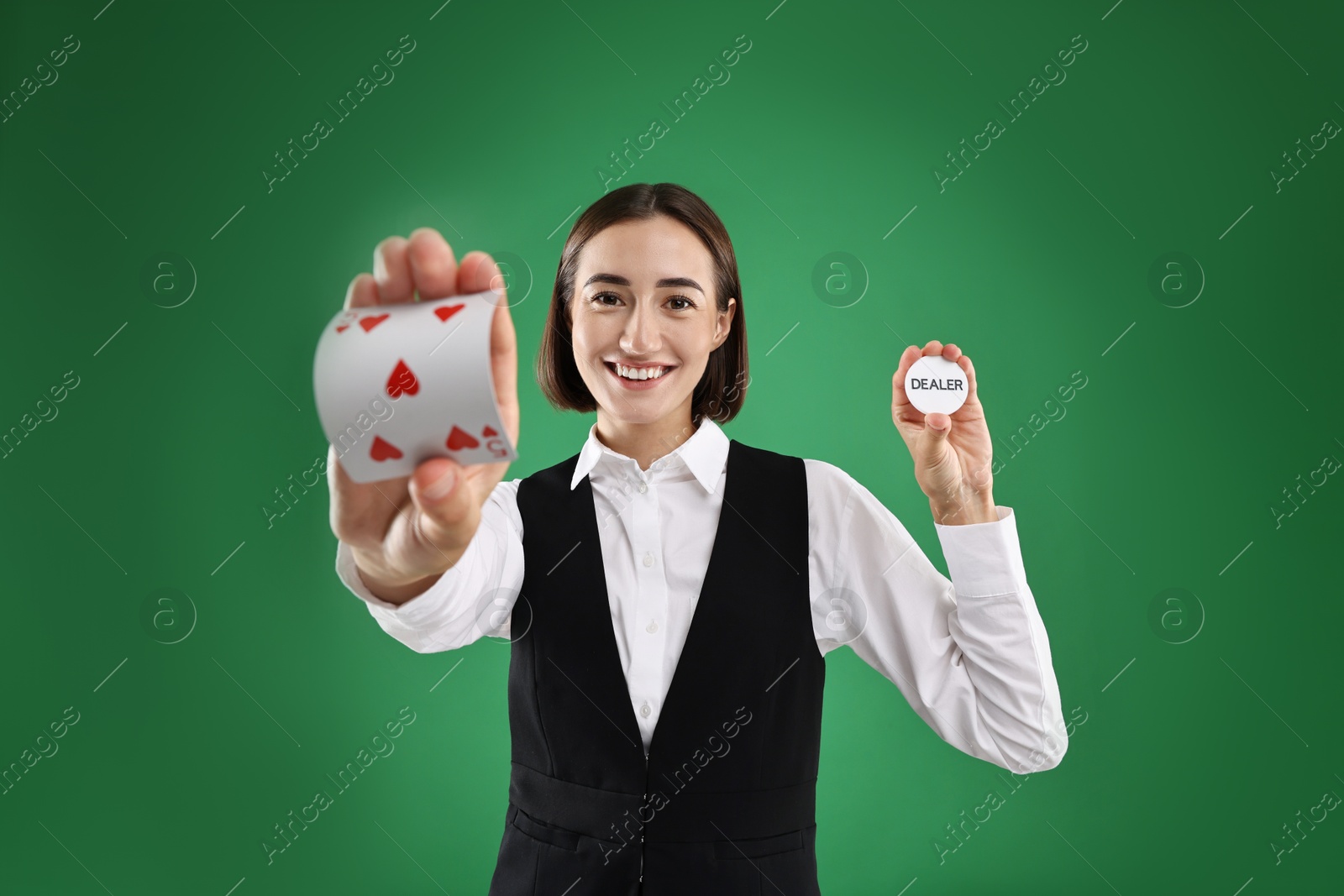 Photo of Croupier with cards and dealer button on green background