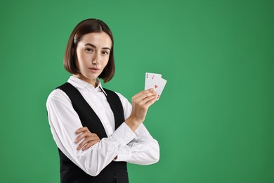 Croupier with playing cards on green background. Space for text