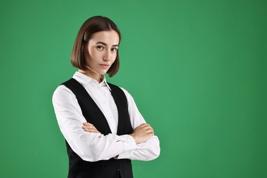 Photo of Portrait of professional croupier on green background. Space for text