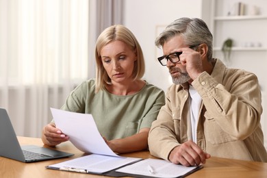 Photo of Couple planning pension budget at table indoors