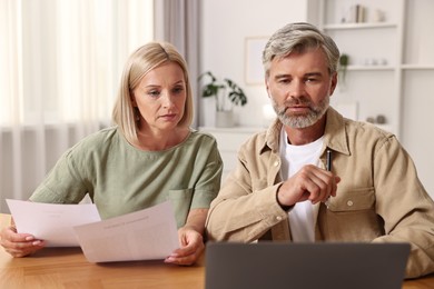 Couple planning pension budget at table indoors