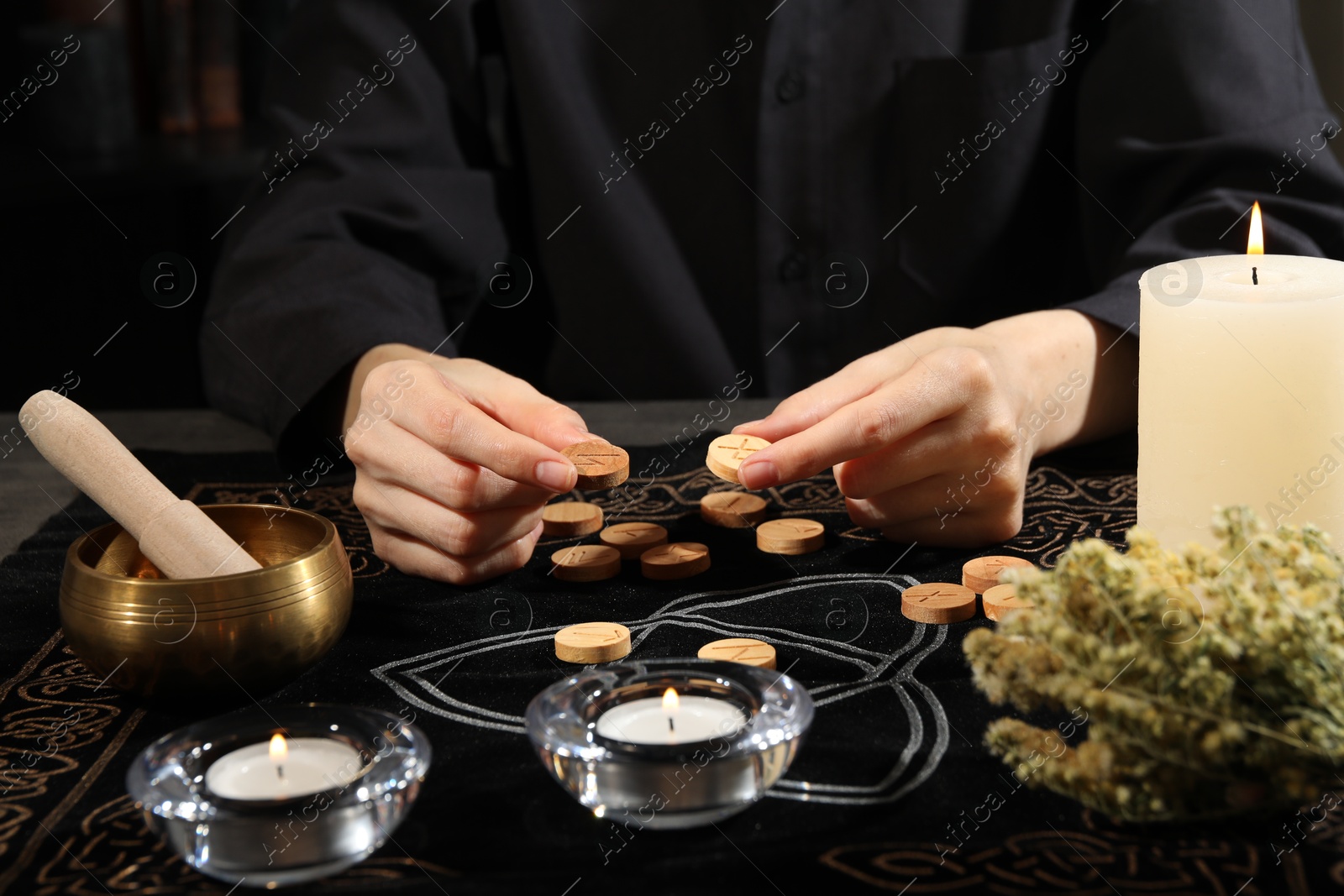 Photo of Woman with wooden runes at divination mat, closeup