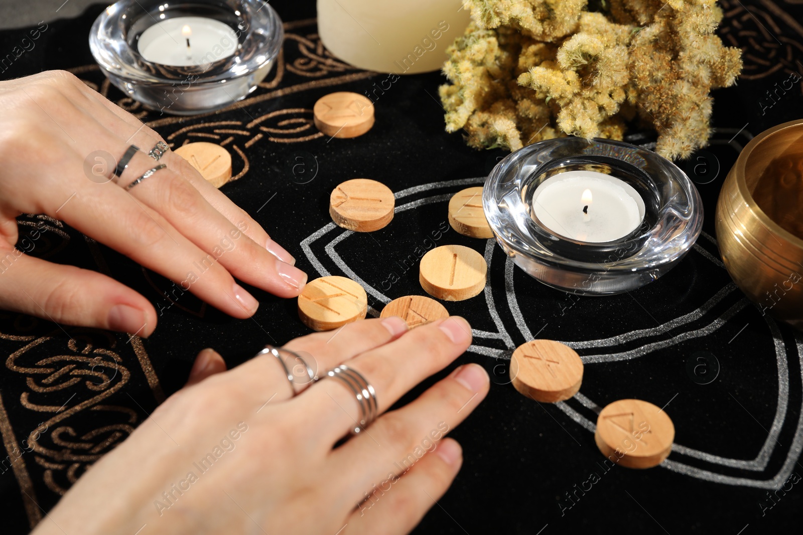 Photo of Woman with wooden runes at divination mat, closeup