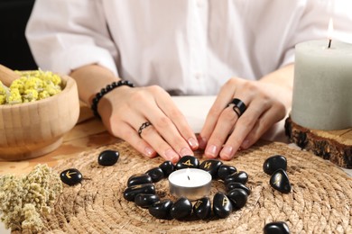 Photo of Woman with black runes at table, closeup