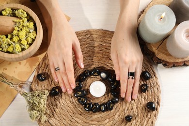 Photo of Woman with black runes at wooden table, top view