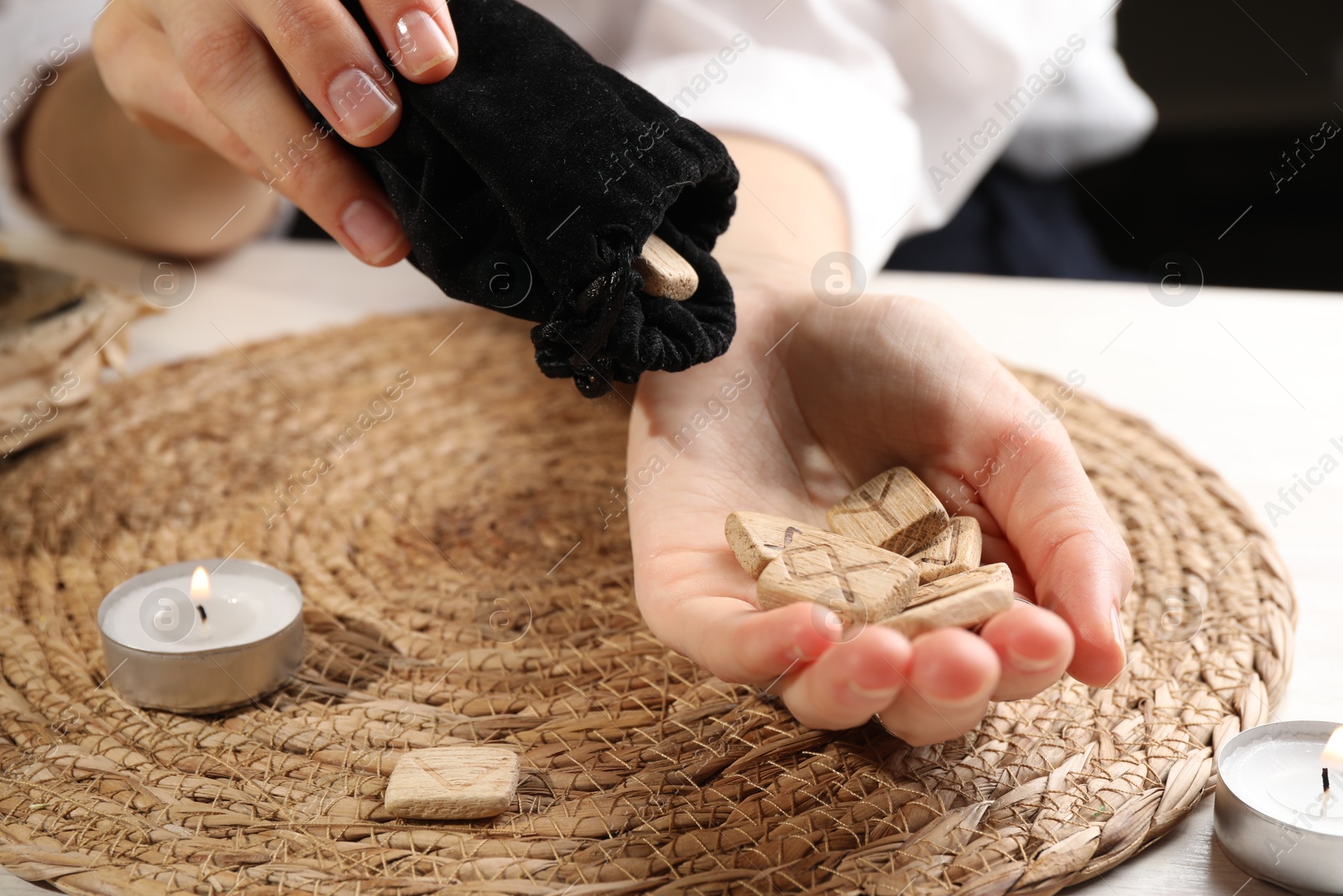 Photo of Woman with wooden runes at table, closeup