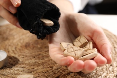 Woman with wooden runes at table, closeup