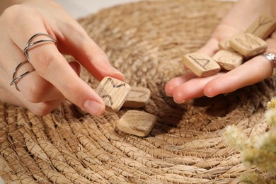 Photo of Woman with wooden runes at table, closeup