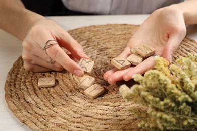 Photo of Woman with wooden runes at table, closeup