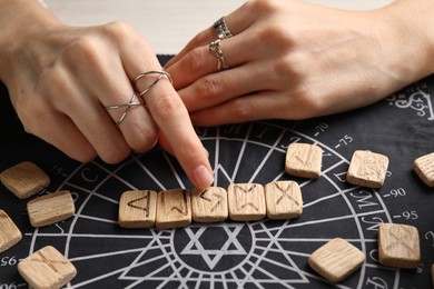 Woman with wooden runes at table, closeup