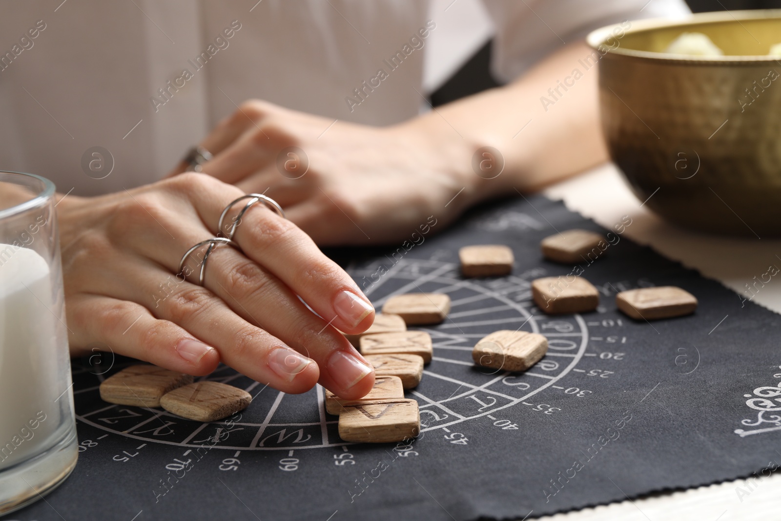 Photo of Woman with wooden runes at table, closeup