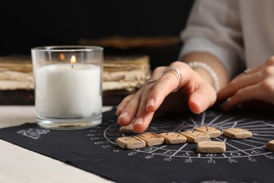 Photo of Woman with wooden runes at table, closeup