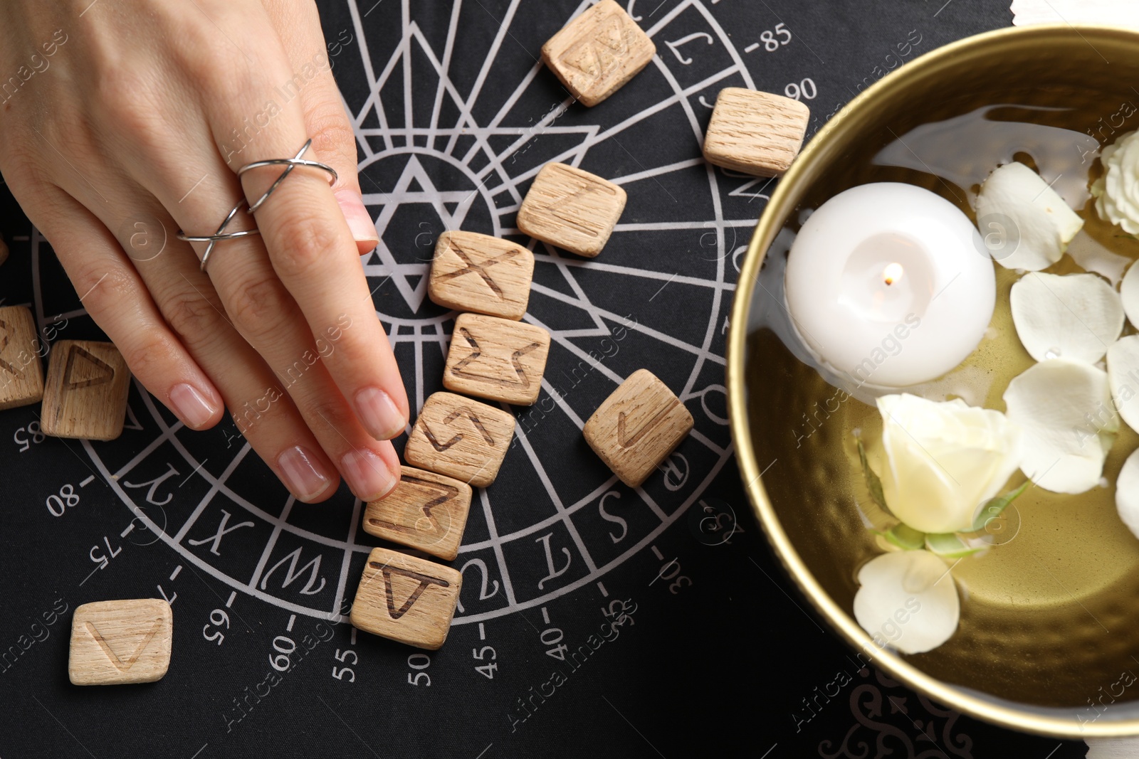 Photo of Woman with wooden runes at divination mat, top view