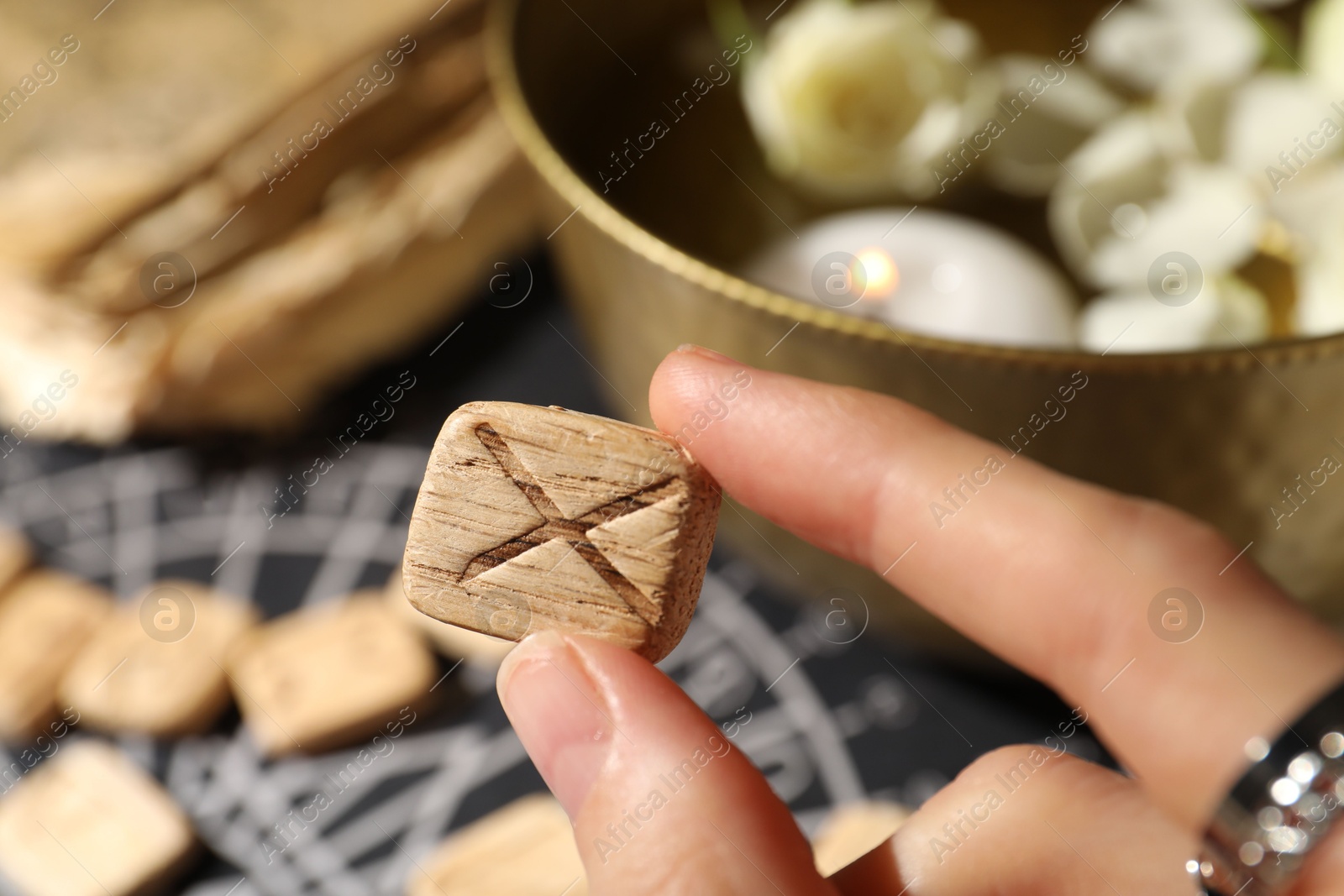 Photo of Woman with wooden rune Gebo at table, closeup