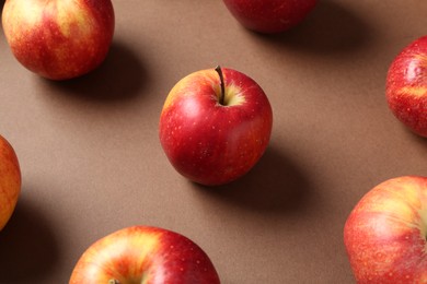 Many ripe red apples on brown background