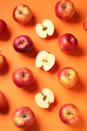 Photo of Whole and cut fresh red apples on orange background, flat lay