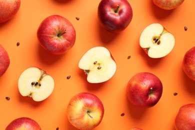 Photo of Fresh red apples and seeds on orange background, flat lay