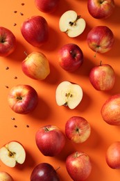 Photo of Fresh red apples and seeds on orange background, flat lay