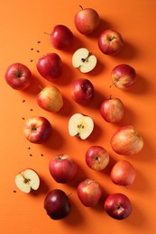 Fresh red apples and seeds on orange background, flat lay