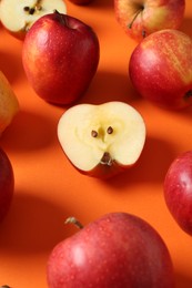 Photo of Many fresh red apples on orange background