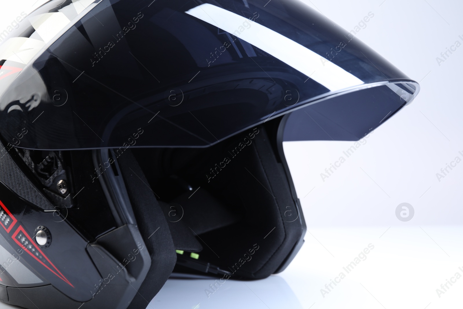 Photo of Modern motorcycle helmet with visor on light background, closeup