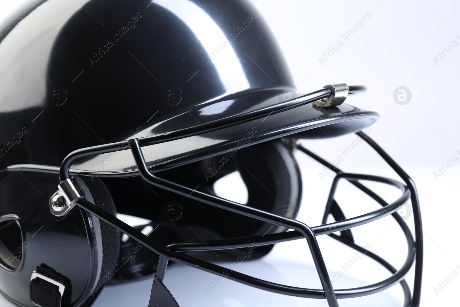 Photo of Black baseball helmet on light background, closeup