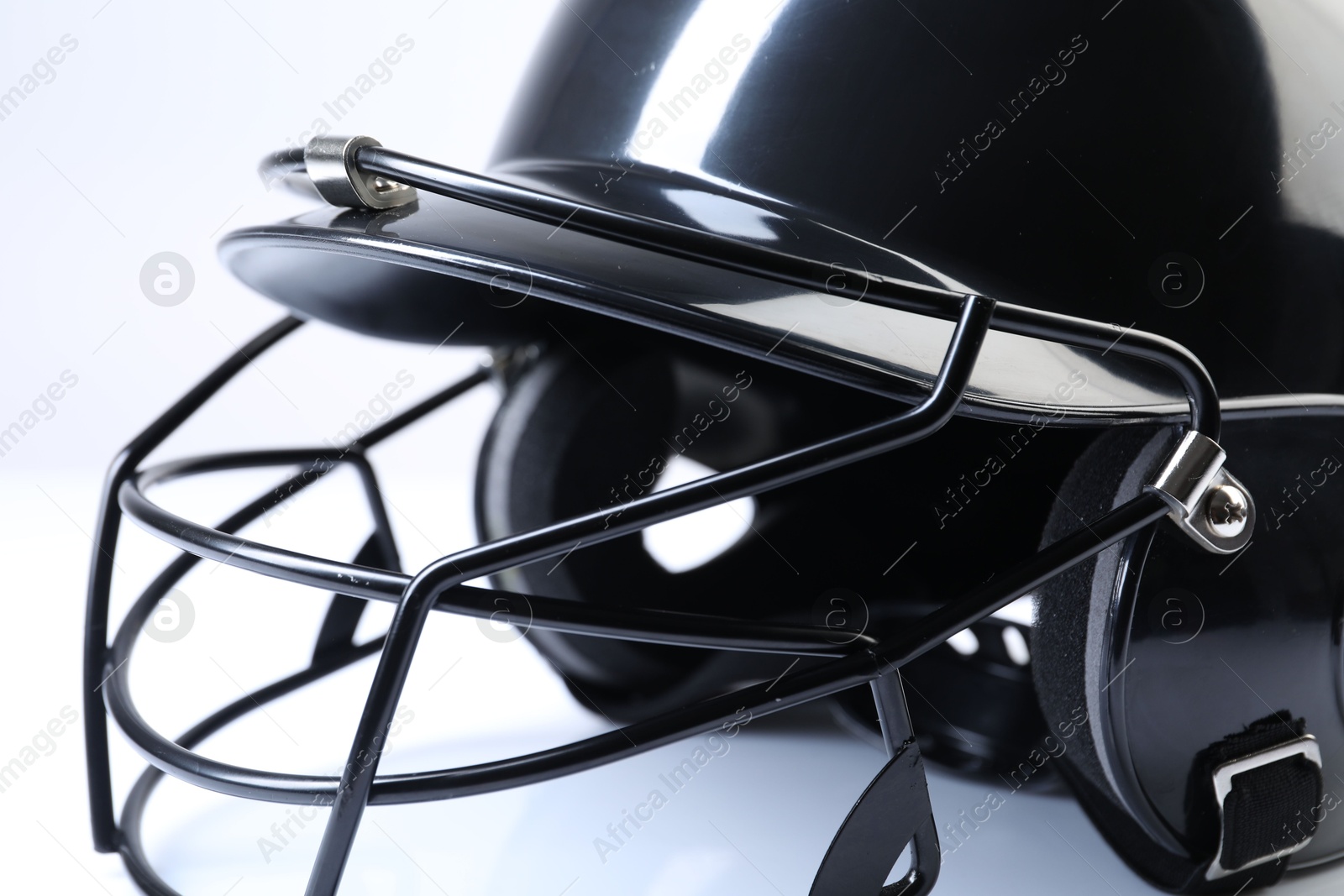 Photo of Black baseball helmet on light background, closeup