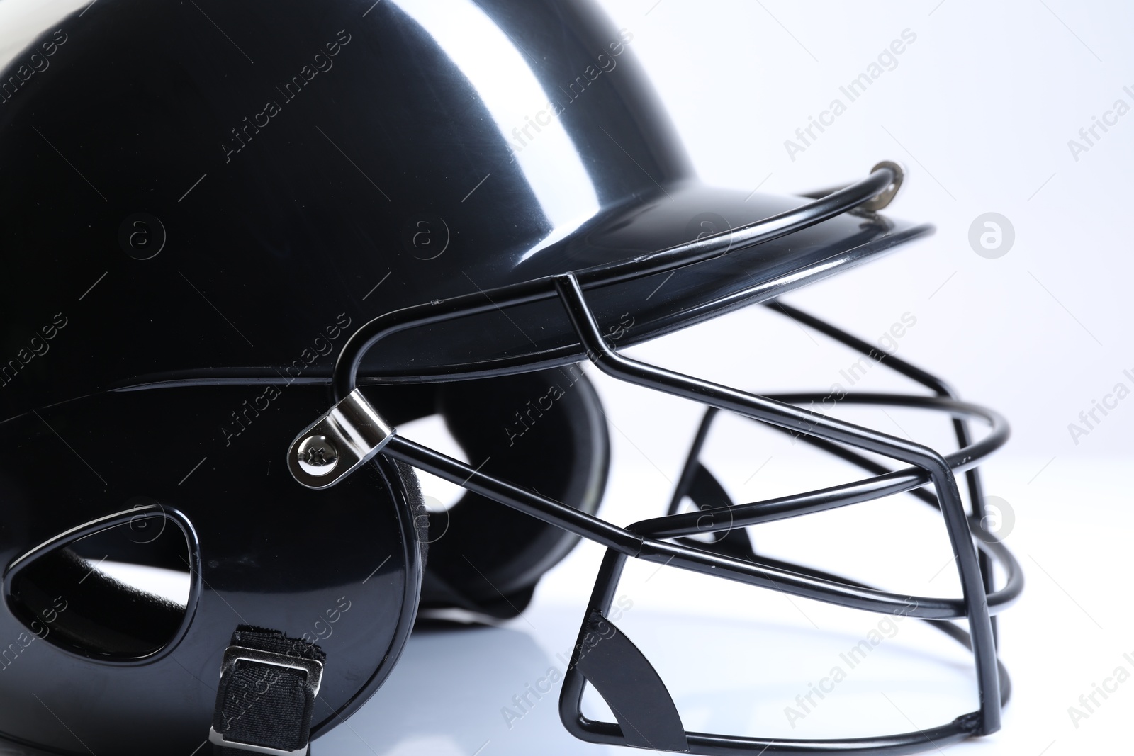 Photo of Black baseball helmet on light background, closeup