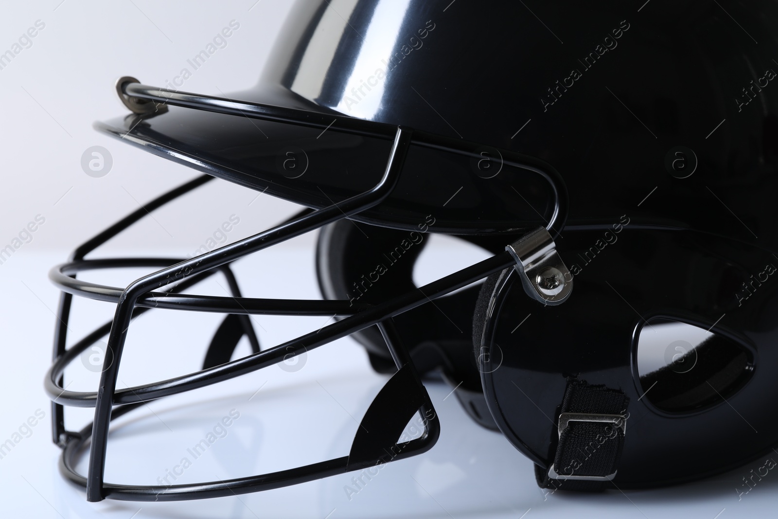 Photo of Black baseball helmet on light background, closeup