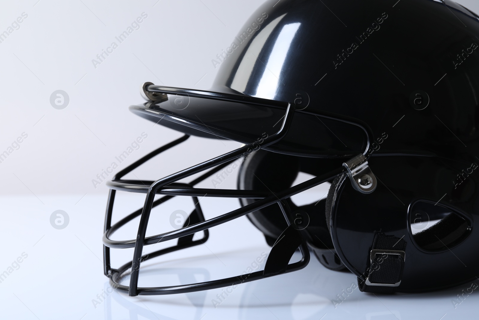 Photo of Black baseball helmet on light background, closeup