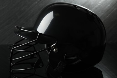 Black baseball helmet on dark gray background, closeup