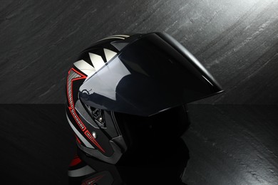 Photo of Modern motorcycle helmet with visor on dark gray background