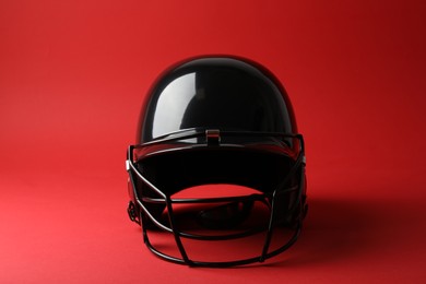 Photo of One black baseball helmet on red background