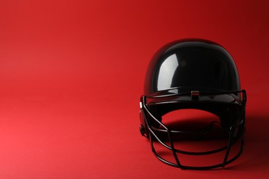 Photo of Black baseball helmet on red background, space for text