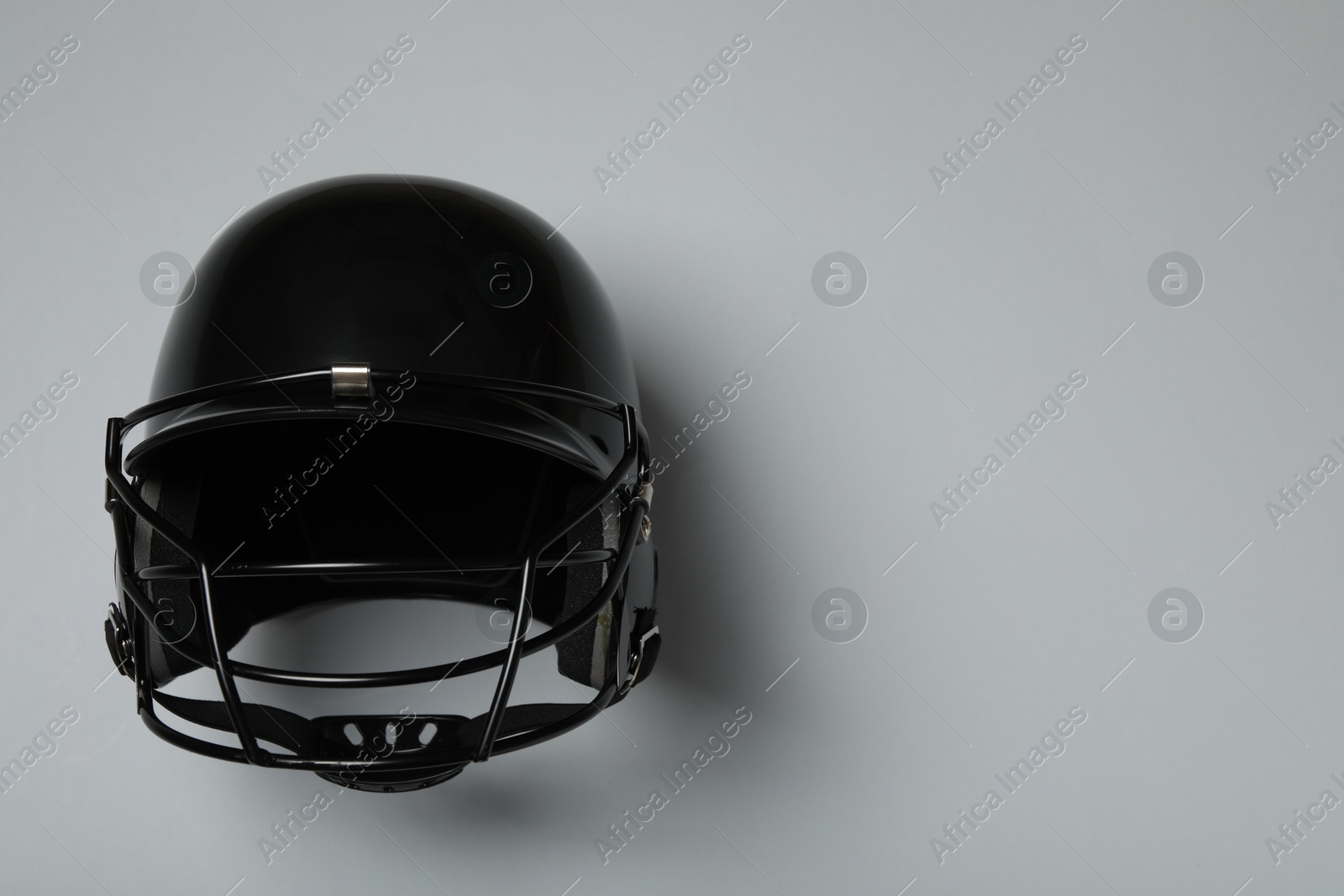 Photo of Black baseball helmet on gray background, top view. Space for text