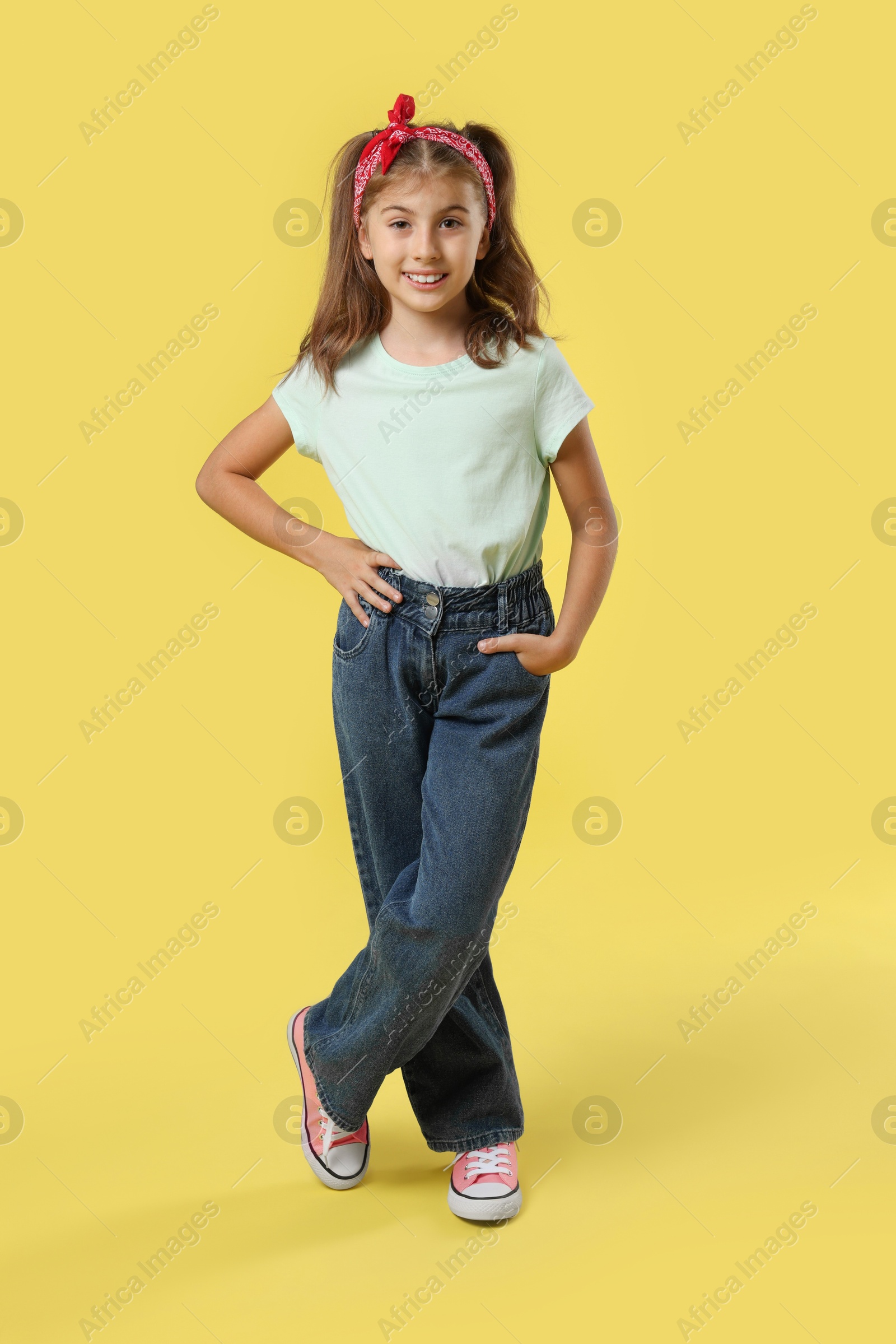 Photo of Full length portrait of cute girl on yellow background