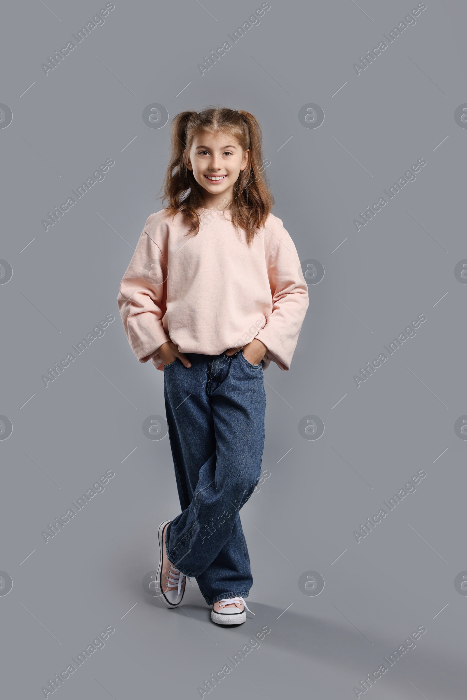 Photo of Full length portrait of cute girl on grey background