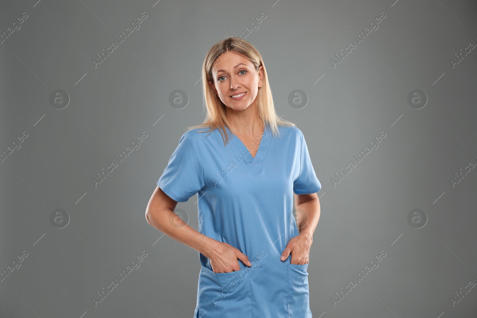 Photo of Portrait of nurse in medical uniform on grey background