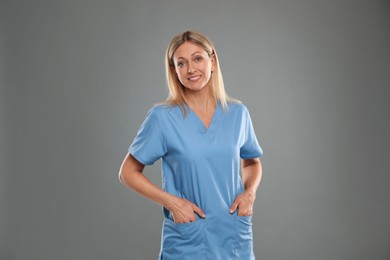 Portrait of nurse in medical uniform on grey background