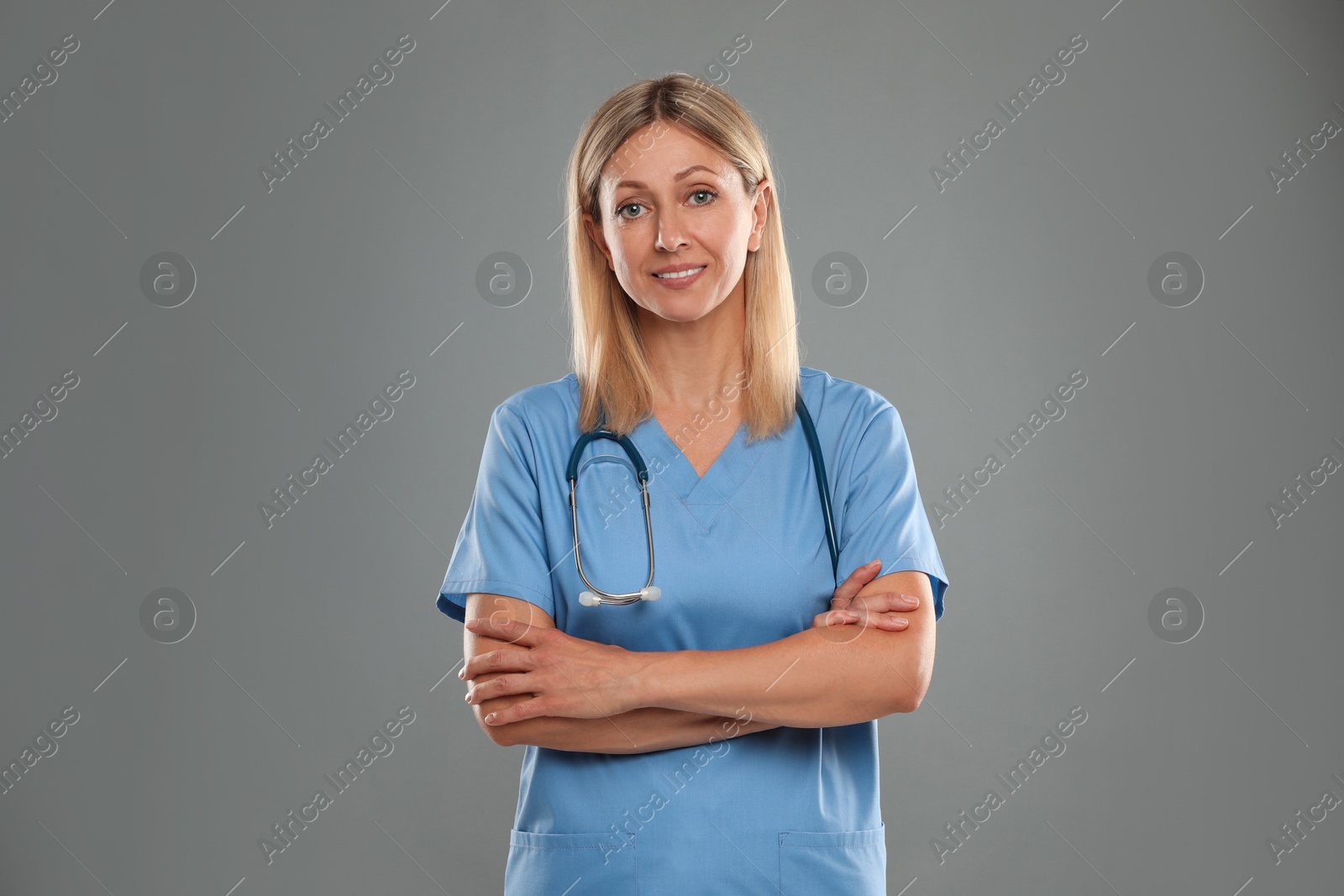 Photo of Portrait of doctor in medical uniform with stethoscope on grey background