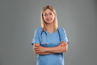 Portrait of doctor in medical uniform with stethoscope on grey background