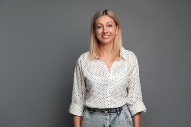 Photo of Portrait of beautiful smiling woman on grey background