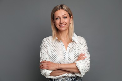 Photo of Portrait of beautiful smiling woman on grey background