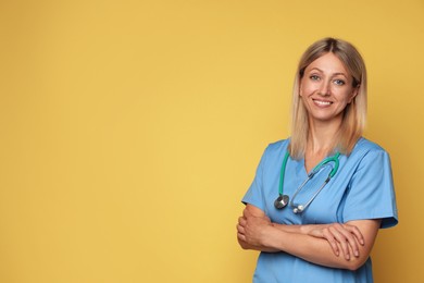 Photo of Portrait of nurse in medical uniform with stethoscope on yellow background, space for text