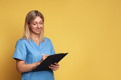 Photo of Portrait of nurse in medical uniform with clipboard on yellow background, space for text